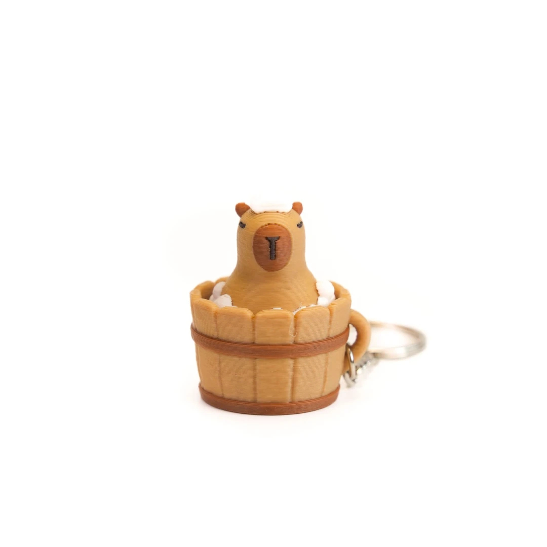 adorable capybara sitting in a wooden-style tub 3d keychain